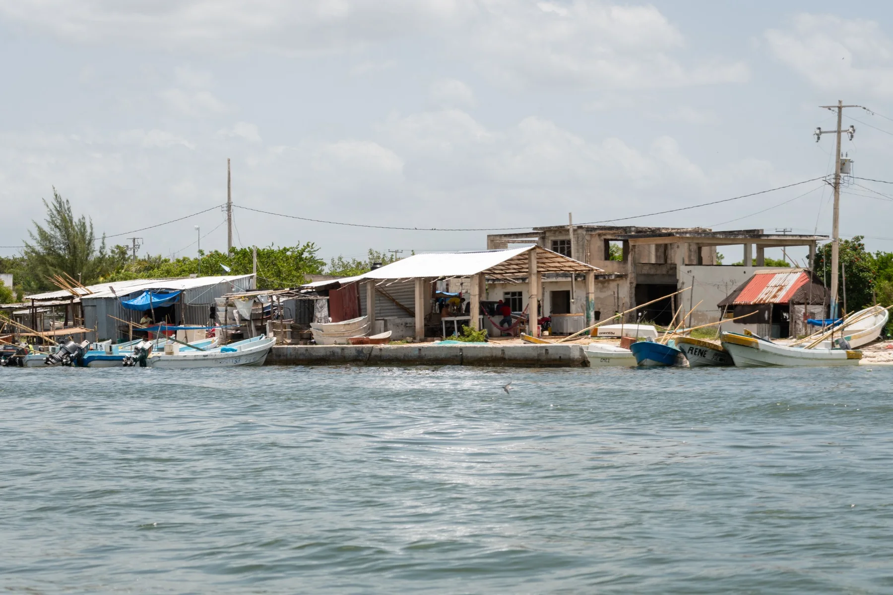 Houses and small fishing boats along a stretch of water.
