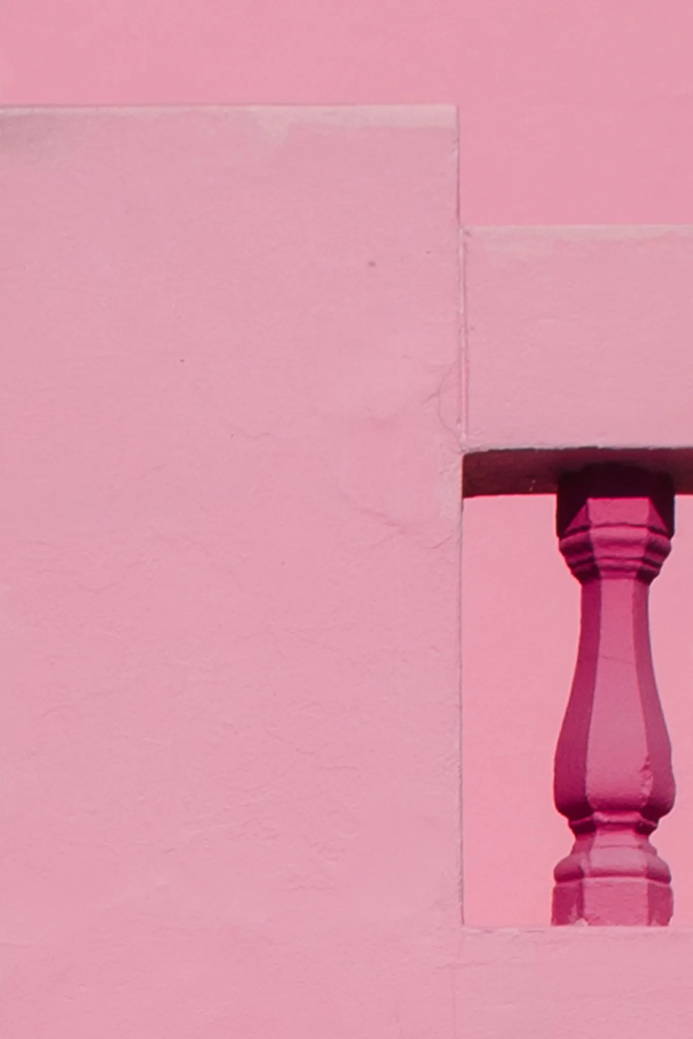 A pink column framed by geometric surfaces in the same colour. A pink column framed by geometric surfaces in the same colour.