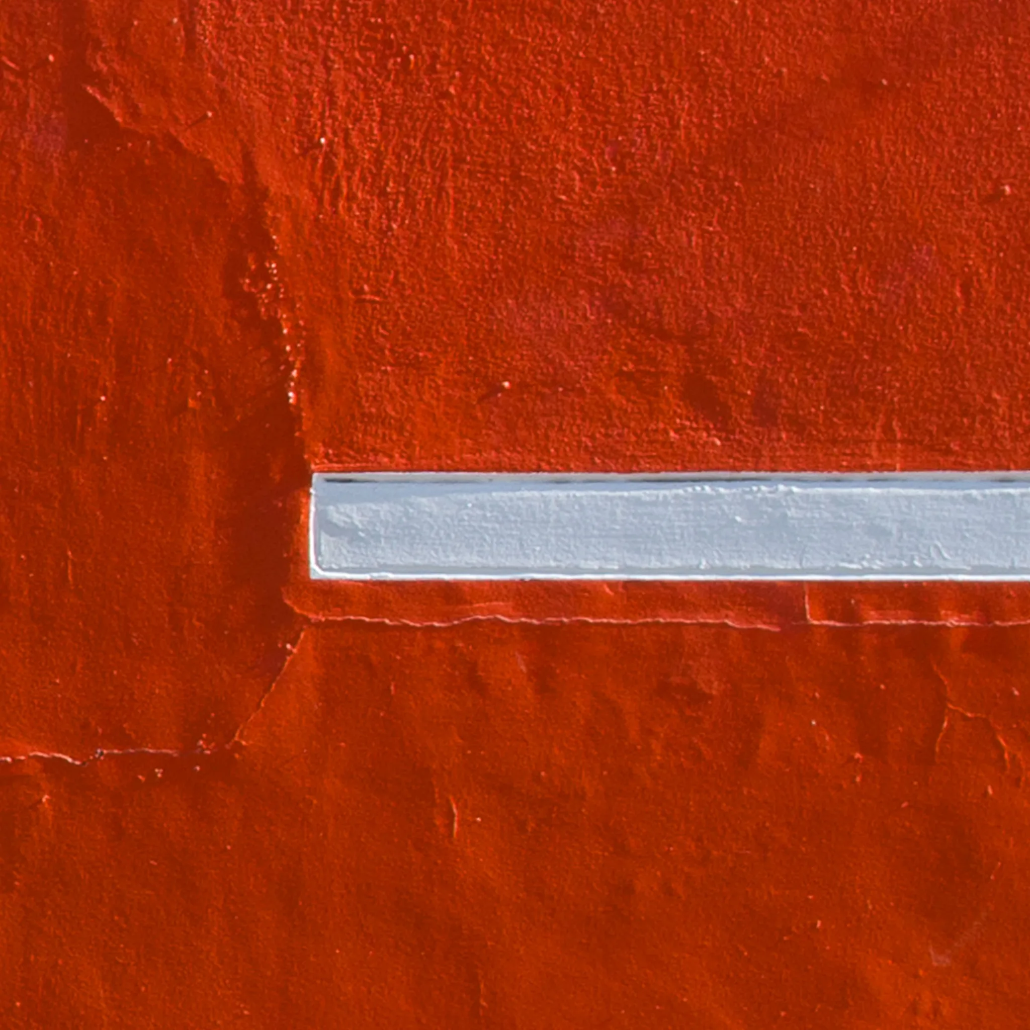 Abstract detail of a red wall with a horizontal white line. Abstract detail of a red wall with a horizontal white line.