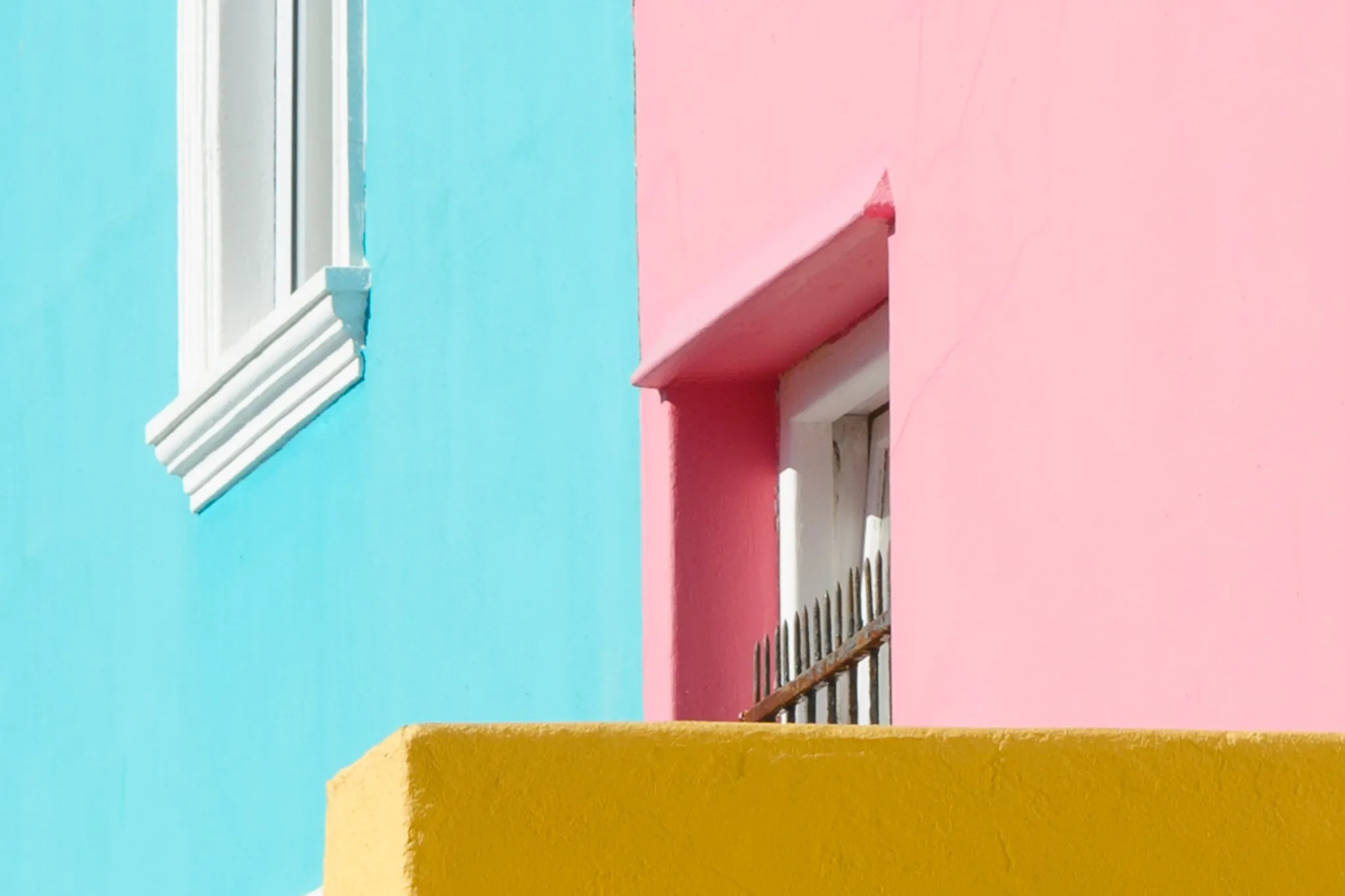 Pastel blue and pink façades with a yellow parapet in Bo-Kaap. Pastel blue and pink façades with a yellow parapet in Bo-Kaap.