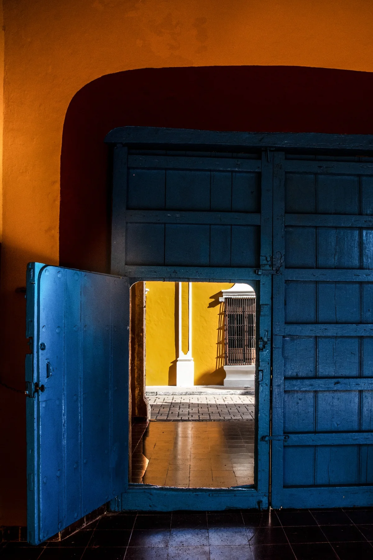 A partly open blue door with warm light filtering through.